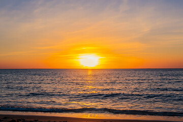 Obraz na płótnie Canvas Beach sunset Head to a beach and witness the golden sun setting over the sea