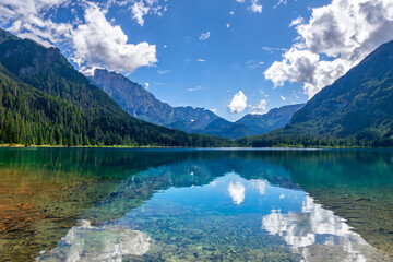 Naklejka na ściany i meble Mountain lake Relax by the side of a crystal-clear lake nestled at the foot of towering mountains, and soak in the beauty of the mountains and their reflections