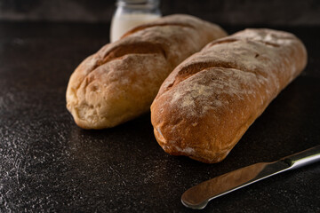 Fresh homemade artisan loaf of baguette breads on rustic background with copy space. sourdough mini baguette breads.
