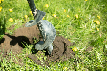 Drill for digging up earth. Planting tool. Excavated soil.