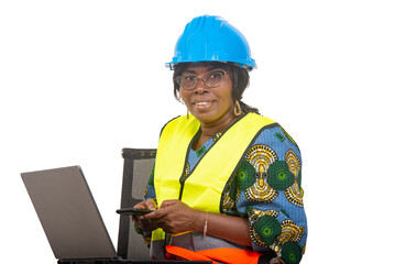 close up of smiling woman engineer in protective helmet working using laptop computer and mobile phone.