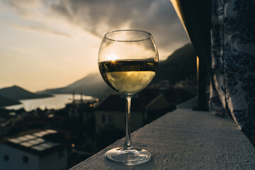 White wine in glass, view of sunset town.