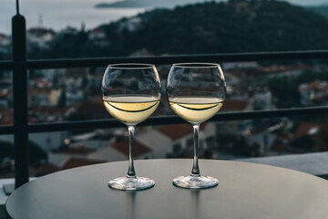 White wine in glass, view of sunset town.