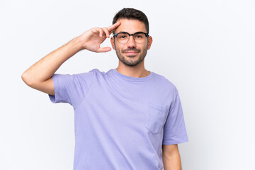 Fototapeta premium Young caucasian man isolated on white background saluting with hand with happy expression