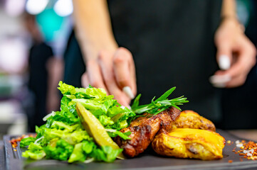 woman chef hand cooking grilled pork neck with baked potatoes and salad