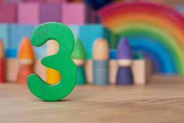 Wooden three on rainbow background of toys