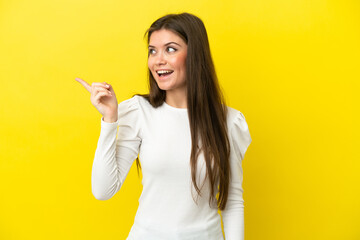 Young caucasian woman isolated on yellow background intending to realizes the solution while lifting a finger up