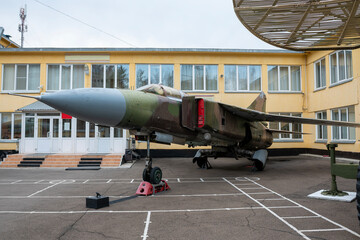 Aircraft in military coloring at a military base in the city.