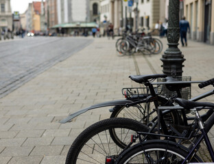 many bicycle on parking lot next to building urban city style street photo.close up wheel tires bike parts,basket,handlebars.bicycle in a row