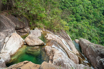 Beautiful green crystal clear water pool in the rock surrounded by dense jungle