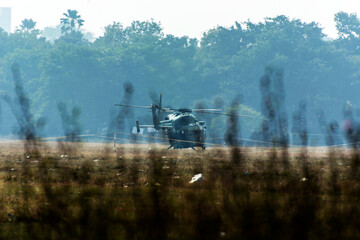 Fototapeta premium Military helicopter is ready to fly on a ground in a city.