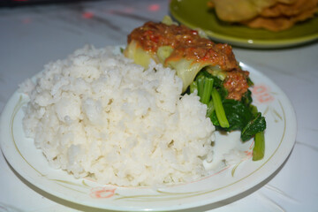 A plate of pecel rice, on a white background.