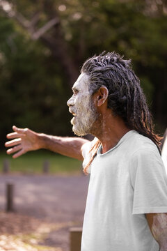 Profile portrait of aboriginal man against a dark bush background