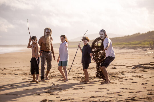 Aboriginal mob at the beach looking at camera elders with school children