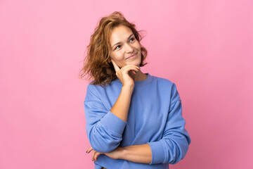 Young Georgian woman isolated on pink background thinking an idea while looking up