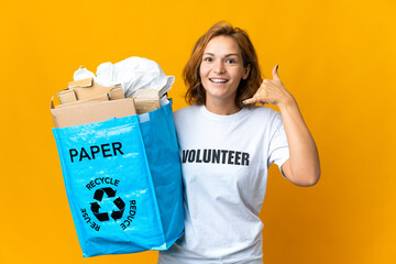 Young Georgian girl holding a recycling bag full of paper to recycle making phone gesture. Call me back sign