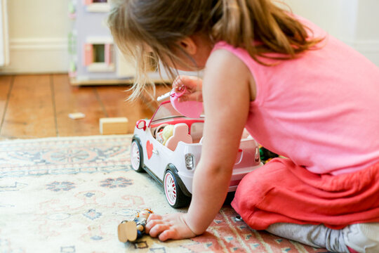 Young girl playing with a toy car