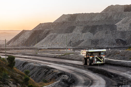 Trucks working late in the day on open cut coal mining extraction site