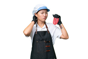 Young caucasian woman wearing an apron and serving fresh cut meat over isolated background having doubts