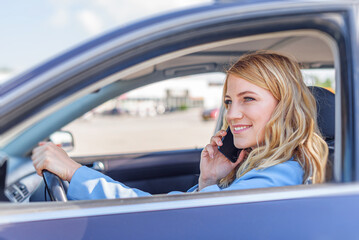 Fototapeta na wymiar Young beautiful woman using smartphone while driving car