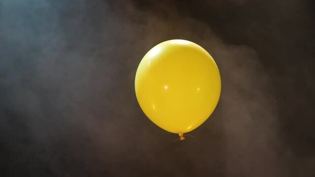 Yellow Inflatable Ball on a Dark Background With Smoke
