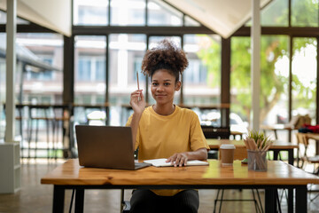 Smiling African American businesswoman, Young freelance business woman in casual look sitting work at coworks space and cafe.