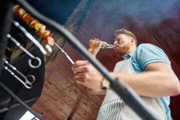 Grill Master's Delight: Charismatic Chef Barbecuing, Beer in Hand, Cheeks Marked with Charcoal