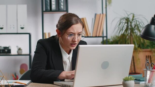 Irritated tired Caucasian business woman while working on laptop, unexpected online website problem, computer virus data loss by hacking. Freelancer feeling mad, broken notebook at office workplace
