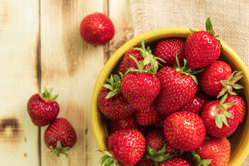 Fresh strawberries on a wooden table, close-up. View from the mountain