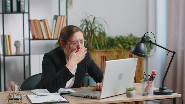 Bored sleepy Caucasian business woman worker working on laptop computer yawning leaning on hand falling asleep at office. Exhausted tired freelancer workaholic girl. Employment, occupation, workless