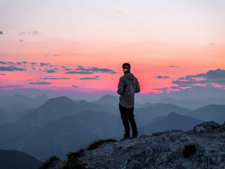 Tourist Staring at the Sunset in the Alps in Tarvisio (Monte Lussari) Italy
