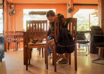 Obraz na płótnie Canvas タイのレストランで猫が座ってて驚く女性