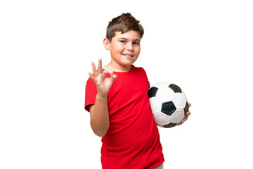 Little caucasian kid over isolated chroma key background with soccer ball and making OK sign