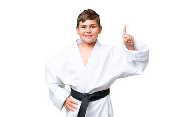 Little caucasian kid doing karate over isolated chroma key background pointing up a great idea