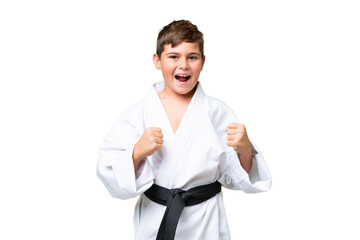 Little caucasian kid doing karate over isolated chroma key background celebrating a victory in winner position © luismolinero
