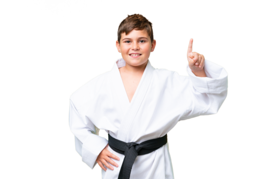 Little caucasian kid doing karate over isolated chroma key background pointing up a great idea