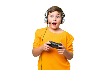 Little caucasian kid playing with a video game controller over isolated chroma key background with surprise facial expression © luismolinero