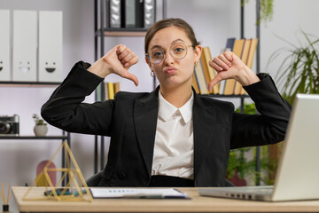 Dislike. Upset Caucasian business woman girl working on laptop computer at office thumbs down sign...