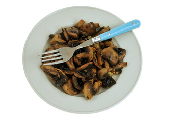 Champignons cuits à l'ail dans une assiette avec une fourchette gros plan sur fond blanc