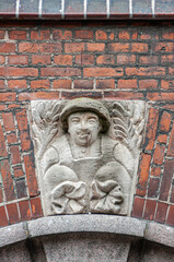 Copenhagen, Denmark - September 14, 2010: Male farmer mural or frieze above garage door, set against red bricks of historic house, now Selma Lamai Design business atelier