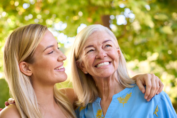 Multi-Generation Family With Senior Mother And Adult Daughter Laughing In Garden 