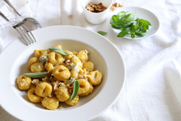 Concetto di cibo italiano. Gnocchi con crema di gorgonzola e noci su sfondo bianco. Vista dall'alto.