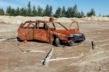 A burnt rusty civilian car with bullet holes. Russian-Ukrainian war, Russian invasion of Ukraine