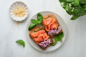 Sandwiches with salted salmon, avocado guacamole, red onions and basil. Smorrebrod. Set of danish open sandwiches. Healthy food, breakfast. Clean eating, dieting, vegan food concept. Top view.