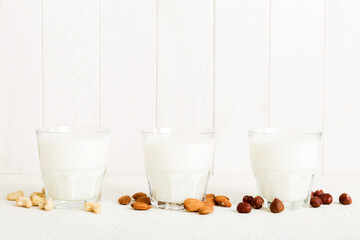 Set or collection of various vegan milk almond, cashew, on table background. Vegan plant based milk and ingredients, top view