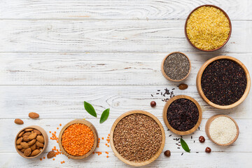 Various superfoods in smal bowl on colored background. Superfood as rice, chia, quinoa, lentils, nuts, sesame seeds, almonds. top view copy space
