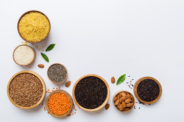 Various superfoods in smal bowl on colored background. Superfood as rice, chia, quinoa, lentils, nuts, sesame seeds, almonds. top view copy space