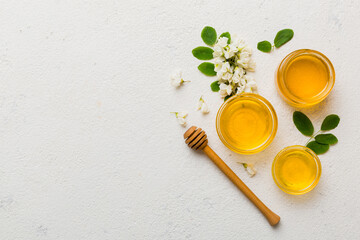Obraz na płótnie Canvas honey jar with acacia flowers and leaves. fresh honey top view flat lay
