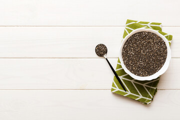 Chia seeds in bowl and spoon on colored background. Healthy Salvia hispanica in small bowl. Healthy...