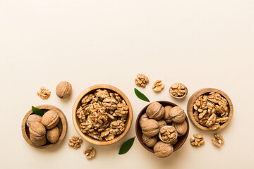 Walnut kernel halves, in a wooden bowl. Close-up, from above on colored background. Healthy eating Walnut concept. Super foods with copy space